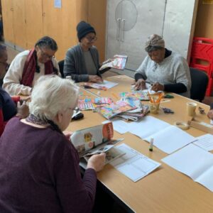 A group of workshops participants working around a table from Medway African and Caribbean Association.