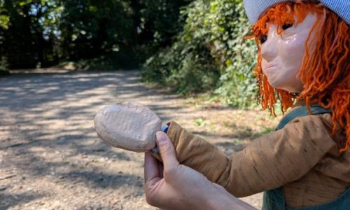 Lyra, with wavy ginger hair and a blue cap, on a woodland trail, ready to dive into the weekend ahead.